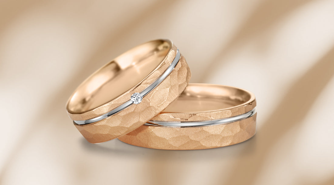 Eheringe mit feinem Hammerschlag aus Roségold 750, akzentuiert durch einen Streifen aus Weissgold und mattierte Oberfläche. Der Damenring bezaubert mit einem funkelnden Diamanten auf dem feinen Weissgoldband.